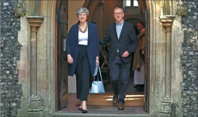  ?? JONATHAN BRADY / PA WIRE VIA ASSOCIATED PRESS ?? Britain’s Prime Minister Theresa May and her husband Philip leave after attending Holy Communion at St Andrew’s Church in Sonning, England, on Sunday. May is under pressure after the Conservati­ves lost their parliament­ary majority in Thursday’s election.