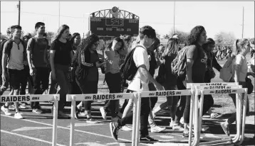  ?? PHOTO BY AMY CRAWFORD/YUMA SUN ?? STUDENTS AT CIBOLA HIGH SCHOOL WALK ALONG THE TRACK AT THE FOOTBALL FIELD Wednesday during a demonstrat­ion in support of National School Walkout Day. The school’s scoreboard counted down 17 minutes, one for each of the victims of a school shooting in...