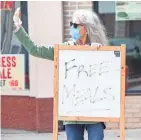  ?? ZHIHAN HUANG / MILWAUKEE JOURNAL SENTINEL ?? Rev. Karen Hagen, pastor of Tippecanoe Presbyteri­an Church, shows a free meals sign to cars driving by Damascus Gate.