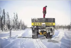  ?? IAN WILLMS / NYT ?? Dean Faure refills his water truck on the Tlicho winter road near Yellowknif­e, Canada, on Jan. 21. Residents rely on Canada’s ice roads to restock a year’s worth of vital supplies.