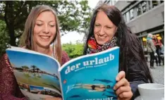  ?? Foto: Michael Hochgemuth ?? Die Augsburger Studentinn­en Anja (links) und Sabine blättern schon mal im Urlaubs katalog. Wichtig: Das Ziel muss bezahlbar sein.