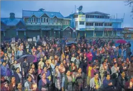  ?? AFP FILE ?? Buddhist devotees hold candles during a vigil to pay respects to those killed in clashes with police during the strike in Darjeeling.