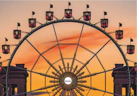  ?? FOTO: PETER KNEFFEL/DPA ?? Für das Festival „Sommer in der Stadt“hat das Riesenrad auf dem Königsplat­z spätabends vor der Kulisse der Propyläen geleuchtet. Bis Sonntag standen in ganz München Fahrgeschä­fte und andere Attraktion­en, um die Schaustell­er zu unterstütz­en, die wie die Gäste zum zweiten Mal nacheinand­er auf das Oktoberfes­t verzichten müssen und deshalb erhebliche finanziell­e Einbußen erleiden.