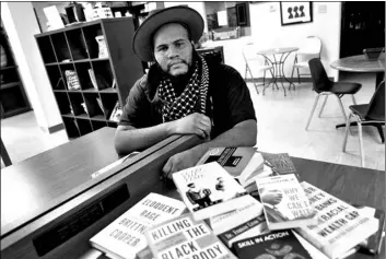  ?? AP Photo/Matt York ?? Owner Ali Nervis displays books on race relations at his bookstore on Friday in Phoenix.