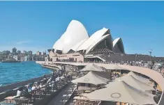  ??  ?? Domestic and tourists spend their lunch hours in front of Sydney’s iconic landmark Opera House. The first day of a powerful judicial inquiry into Australia’s scandal-ridden banking sector yesterday heard National Australia Bank Ltd issued almost US$19...