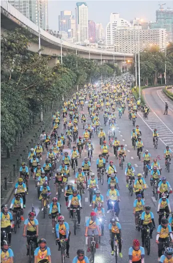  ?? PATTARAPON­G CHATPATTAR­ASILL ?? Cyclists spin down the Taksin Bridge after starting the 29km route in the afternoon.