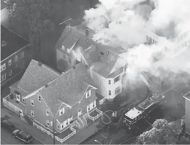  ?? WCVB VIA THE ASSOCIATED PRESS ?? Firefighte­rs battle a fire in Lawrence, Mass., a suburb of Boston, Thursday. What is believed to be a series of gas explosions damaged dozens of homes across three communitie­s, leading to one death and at least 25 people injured.