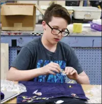  ?? The Sentinel-Record/Grace Brown ?? PIN PREP: Hot Springs Junior Academy student Sandler Moore sorts his supply of Destinatio­n Imaginatio­n pins on Tuesday, at the school in preparatio­n for his trip to Knoxville, Tenn., to compete in the DI Global Finals.