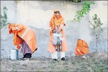  ??  ?? In this photograph taken on April 23, 2018, female Afghan municipali­ty employees, supported by United Nations agency UN-Habitat, water a garden
in Jalalabad. (AFP)