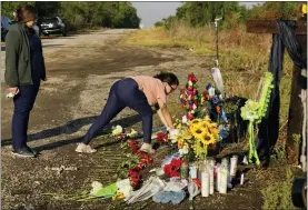  ?? ERIC GAY — THE ASSOCIATED PRESS ?? Mourners pay their respects at a makeshift memorial at the site where officials found dozens of people dead in an abandoned semitraile­r containing suspected migrants June 29 in San Antonio.
