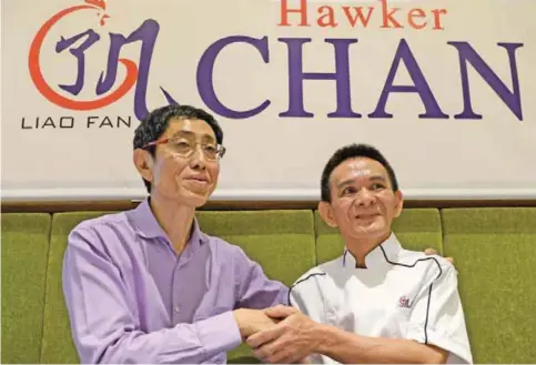  ?? — AFP ?? Chef Chan Hon Meng (R), also known as “Hawker Chan”, and Hersing Chairman Harry Chua shake hands after a press conference in Singapore yesterday.