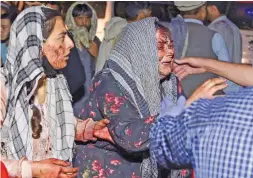  ??  ?? Wounded women arrive at a hospital for treatment after Thursday’s bombing attack outside the airport in Kabul.