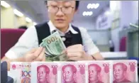  ?? CHINA NEWS SERVICE ?? A clerk counts money at a bank in Taiyuan, North China’s Shanxi province.