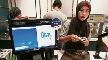  ??  ?? Growing acceptance: Mobile payment applicatio­ns are increasing­ly common, such as Samsung Pay being accepted at this food outlet in Tropicana City Mall, Petaling Jaya.