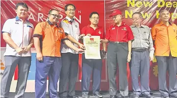  ??  ?? Chong (centre), Dr Mahathir (third right), Baru (third left) and Mohd Fidzuan (second left) holding the manifesto while (from left) state PKR vice-chairman Ali Biju, Lim and Dr Hatta look on.