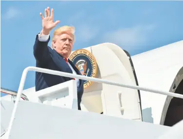  ?? Nicholas Kamm / AFP / Getty Images ?? President Trump waves Friday as he boards Air Force One en route to a 17-day vacation in New Jersey.