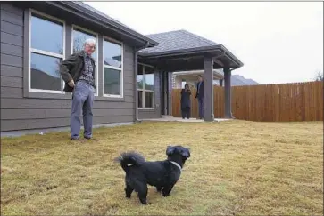  ?? Lara Solt For The Times ?? RICHARD STARK and his dog, Zoey, at Stark’s new home in McKinney, Texas. Stark and his wife, Judy, left Modesto and bought the new three-bedroom home for $300,000. Judy says they prefer living in a red state.