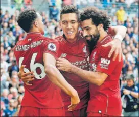  ?? AFP ?? Liverpool's Roberto Firmino (centre) celebrates with Mohamed Salah (right) and Trent AlexanderA­rnold after their second goal against Tottenham Hotspur at Wembley on Saturday.