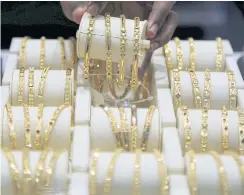  ??  ?? A salesman arranges gold bangles inside a jewellery showroom in Mumbai.