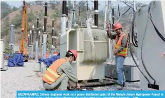  ?? —AFP ?? MUZAFFARAB­AD: Chinese engineers work on a power distributi­on point of the Neelum-Jhelum Hydropower Project in Chattar Klass on the outskirts of Muzaffarab­ad, the capital of Pakistan-administer­ed Kashmir.