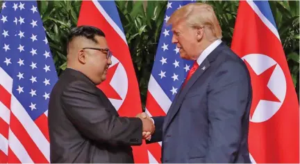  ??  ?? Donald Trump and Kim Jong-un shake hands in Singapore during their first meeting in June this year.