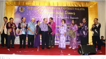  ??  ?? Padum president Cooplay Ngipa (fifth right) helps Uggah put on a Bidayuh blazer presented as a memento, as Manyin (fourth left), Gerawat (third left) and others look on.