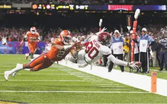  ?? Tom Pennington / Getty Images ?? Alabama’s Mack Wilson scores on an intercepti­on as Clemson’s Kelly Bryant tries to stop him.