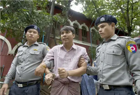  ?? (AP Photo/Thein Zaw) ?? Reuters journalist Kyaw Soe Oo talks to journalist­s as he leaves the court after trial Monday, July 9, 2018, in Yangon, Myanmar.