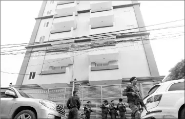  ??  ?? Cambodia police stand at a condo where they arrested dozens of young Chinese men and women working on a call centre to carry out a telephone and internet scam on victims in China in Phnom Penh, Cambodia. — Reuters photo