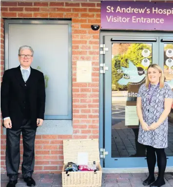  ??  ?? Kindness Co-op Funeralcar­e’s Fraser Graham hands the hamper over to the hospice’s Claire Dalgleish