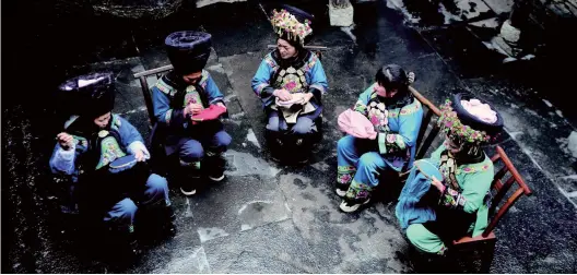  ??  ?? Women from the Miao ethnic group produce embroideri­es as souvenirs for tourists in Fenghuang County, Hunan Province, on February 18.