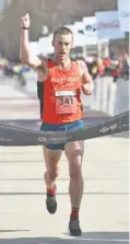  ?? STAFF PHOTO BY ANGELA LEWIS FOSTER ?? Christian Thompson crosses the finish line as he wins the Chattanoog­a Marathon on Sunday. Runners completed a 26.2-mile course that started and finished downtown.