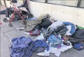  ?? JANIE HAR — THE ASSOCIATED PRESS FILE ?? People sleep amongst discarded clothing and used needles July 25, 2019on a street in the Tenderloin neighborho­od in San Francisco.