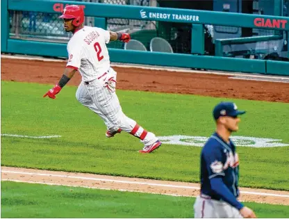  ?? PHOTOS BY MATT SLOCUM/AP ?? Phillies second baseman Jean Segura points to the dugout after hitting a winning RBI single in the bottom of the 10th inning off Braves reliever Nate Jones on opening day in Philadelph­ia on Thursday. It was the Braves’ third straight opening-day loss. BELOW: Phillies catcher J.T. Realmuto reacts after the Braves’ Cristian Pache strikes out in the eighth inning.