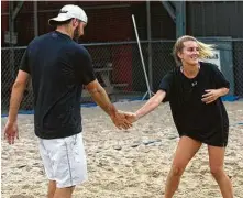  ??  ?? Michael Lyons and Lauren Lyons celebrate after winning a point while playing in a sand volleyball tournament.