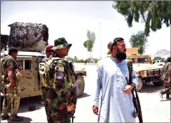  ?? JAVED TANVEER/AFP VIA GETTY IMAGES ?? Afghan security personnel stand guard along the road on Friday amid ongoing fighting between Afghan security forces and Taliban fighters in Kandahar.