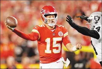  ?? ?? Kansas City Chiefs quarterbac­k Patrick Mahomes (15) throws under pressure from Las Vegas Raiders safety Johnathan Abram (24) during the first half of an NFL football game in Kansas City, Mo. (AP)