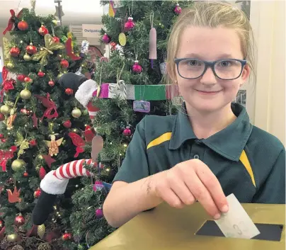  ?? PHOTO: ALEXIA JOHNSTON ?? Festive spirit . . . Emma Corson (9) votes for her favourite Christmas tree after admiring the 14 on display at Dunstan Hospital.