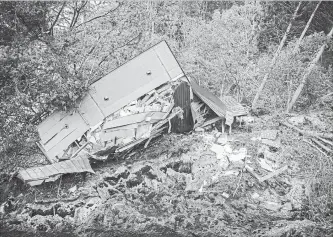  ?? CARL COURT GETTY IMAGES ?? A house lies in ruins Friday after being hit by a landslide caused by an earthquake in Atsuma, Japan.