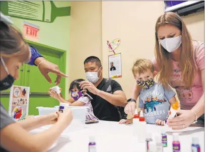  ?? Erik Verduzco Las Vegas Review-journal @Erik_verduzco ?? Matthew Okada, clockwise from top left, with his daughter Alessa, and Nichole Williams, with her children Aiden Williams Romero, 4, and Amelia, 8, work on a project Wednesday at the Children’s Discovery Museum in Las Vegas.