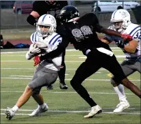  ?? HERALD PHOTO BY DALE WOODARD ?? Catholic Central Cougar Patrick Bulger tries to get past Brandon Francis of the Chinook Coyotes in the Southern Alberta High School Football League Tier II playoff Friday night at the University of Lethbridge Stadium.