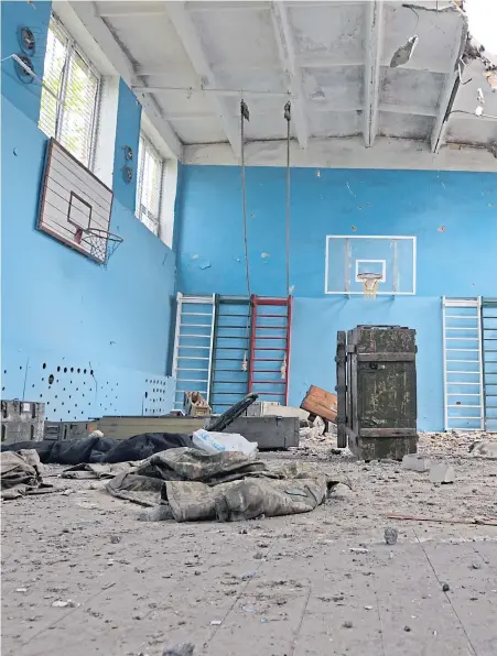  ?? ?? Basketball hoops and climbing frames remain but the school gym hall in Sorokivka is in ruins after being used as a base by both Russians and the Ukrainians troops