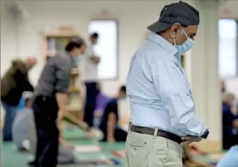  ?? Pam Panchak/Post-Gazette ?? Attendees pray during the jumah service at the Muslim Community Center of Greater Pittsburgh on Friday in Monroevill­e. Ramadan has brought some Muslims back to in-person worship services, with participan­ts social distancing and bringing their own prayer rugs.