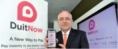  ??  ?? Schiesser showing a applicatio­n for DuitNow at its media briefing yesterday. DuitNow will be open to the public in December 2018 with seven banks having taken the initiative to reach out to their customer. — Bernama photo