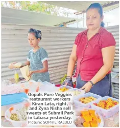  ?? Picture: SOPHIE RALULU ?? Gopals Pure Veggies restaurant workers Kiran Lata, right, and Zyna Nisha sell sweets at Subrail Park in Labasa yesterday.