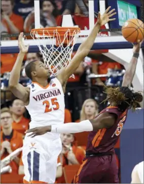  ?? AP PHOTO/STEVE HELBER ?? Virginia forward Mamadi Diakite (25) defends as Virginia Tech forward Chris Clarke (15) takes a shot during the second half of an NCAA college basketball game in Charlottes­ville, Va., Saturday, Feb. 10, 2018. Virginia Tech won the game 61-60in overtime.
