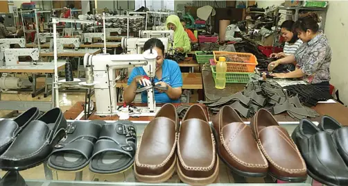  ?? GHOFUUR EKA/ JAWA POS ?? LARIS: Salah satu outlet UKM sepatu dan sandal di kampung eks Dolly. Selain dijual langsung, produk mereka dijual via online. Kini peminatnya hingga luar negeri.