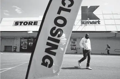  ?? SETH WENIG/AP ?? People walk through the parking lot of a Kmart on Monday in Avenel, N.J. The store is scheduled to close Saturday.