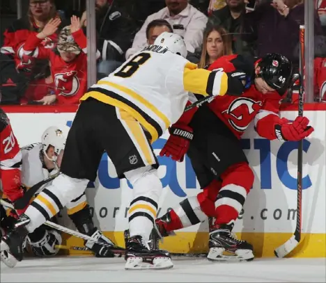  ?? Bruce Bennett/Getty Images photos ?? Brian Dumoulin checks New Jersey’s Miles Wood Tuesday night at Prudential Center in Newark.