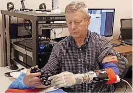  ?? [PHOTO BY UNIVERSITY OF UTAH] ?? Using a robotic arm that allowed him to feel objects again, Keven Walgamott was able to pick a grape without crushing it. Suzanne Wendelken, an Oklahoma City native, says she worked on a research team developing the advanced prosthetic hands.